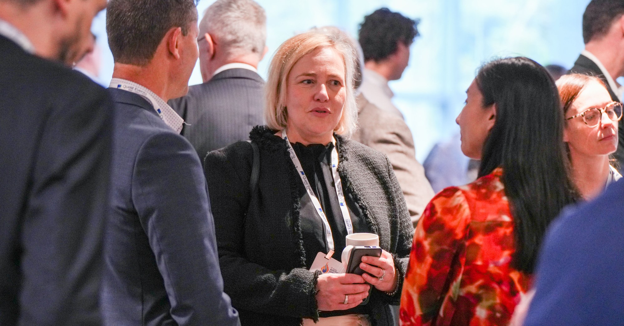 Event shots from Women in procurement, several people standing together talking