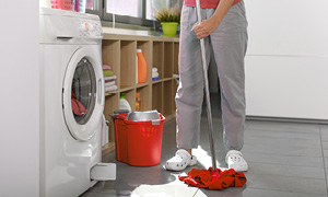 Ženska čisti tla, ker ji pralni stroj pušča vodo