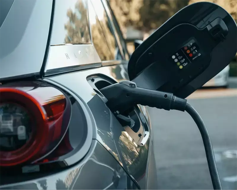 EV automobile at a charging station with charger inserted