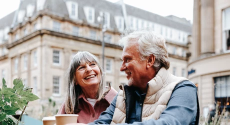  A happy senior couple enjoy a moment together while seated at an outdoor café 