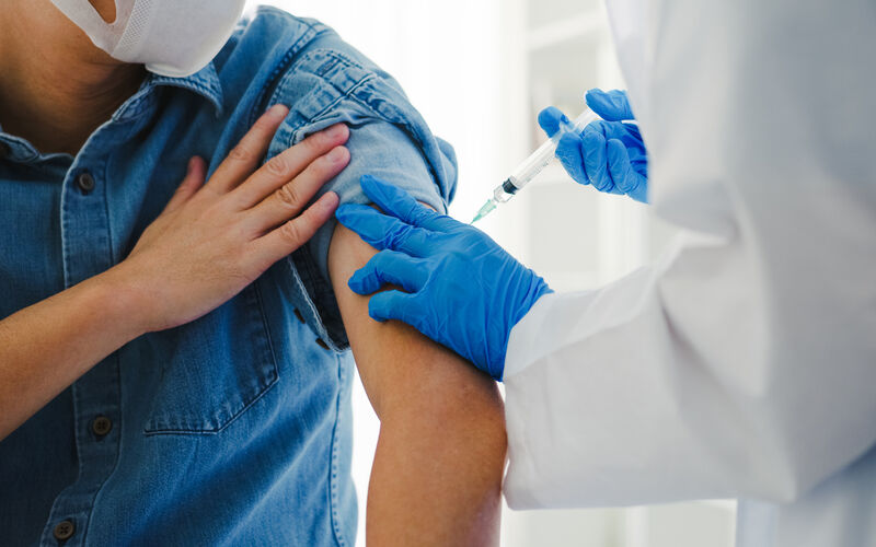 image of medical provider holding a syringe to a patient's arm