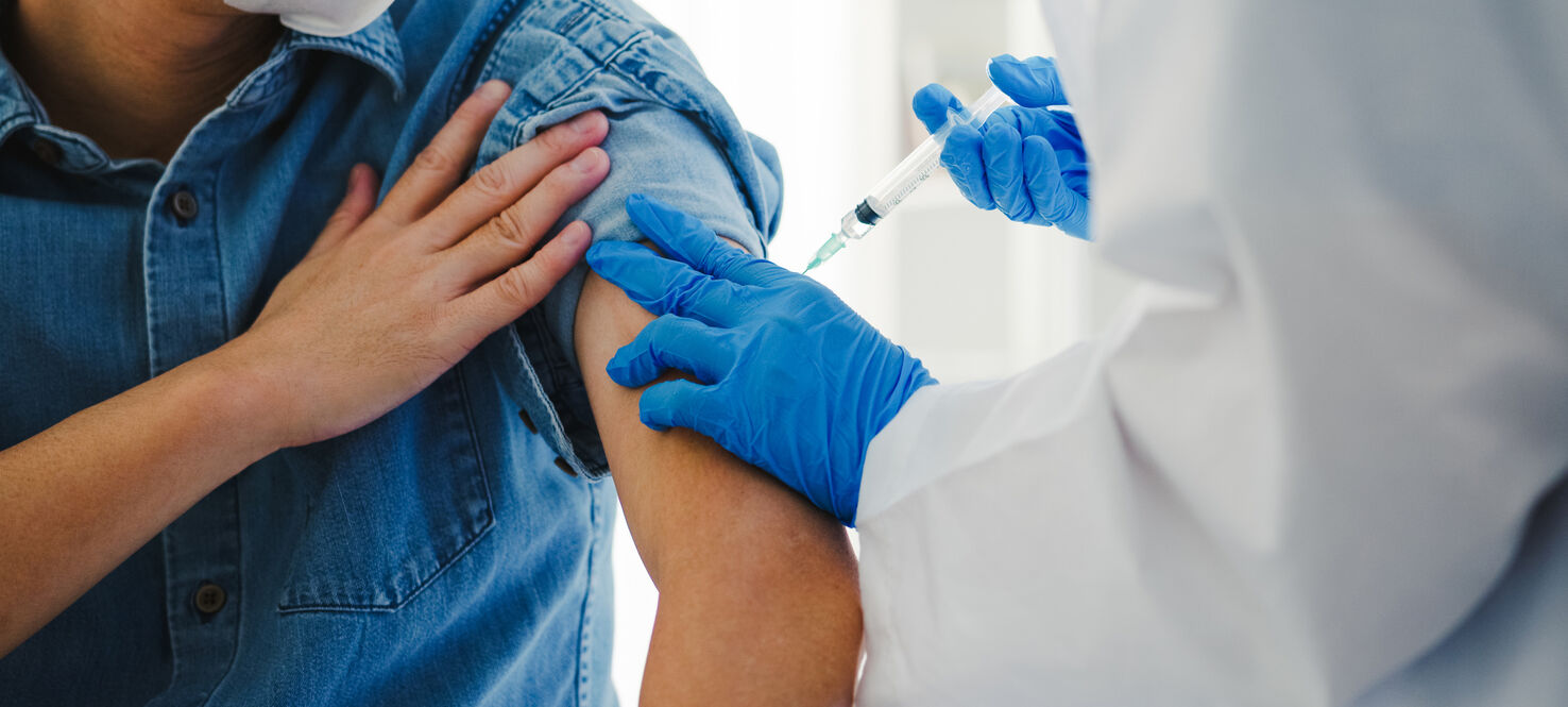 image of medical provider holding a syringe to a patient's arm