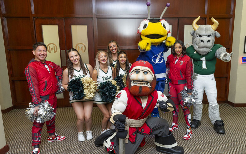 Moffitt patients and team members pose for photos with Tampa Bay sports team mascots and cheerleaders.